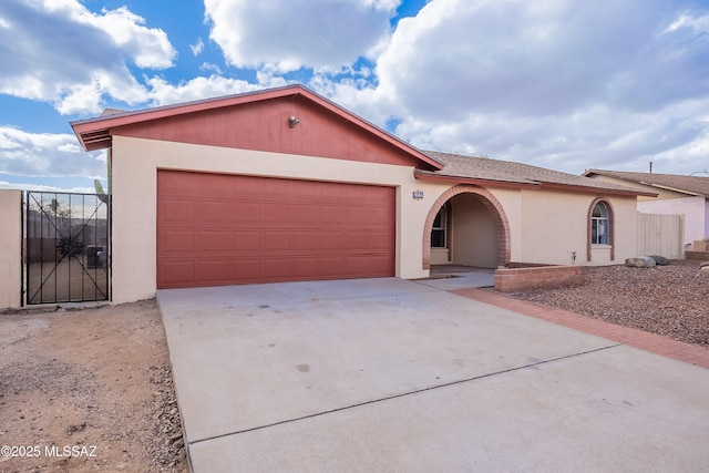 single story home with stucco siding, driveway, and a garage