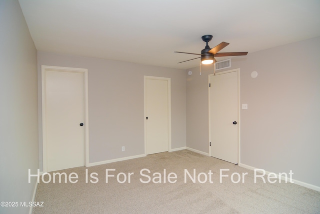 unfurnished bedroom featuring visible vents, multiple closets, baseboards, and carpet flooring