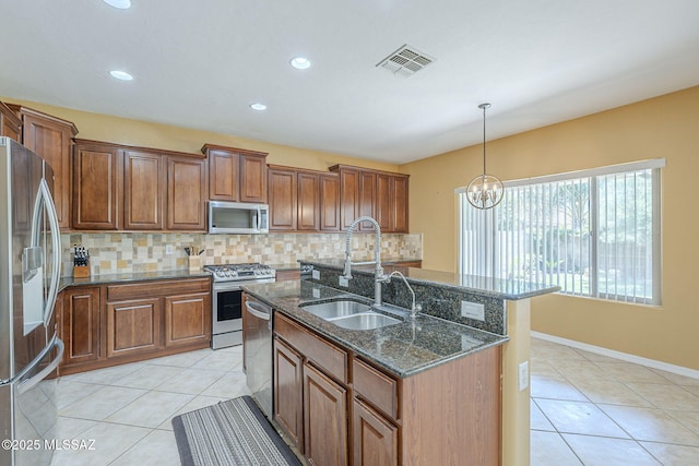 kitchen featuring stainless steel appliances, light tile patterned floors, decorative backsplash, and a sink