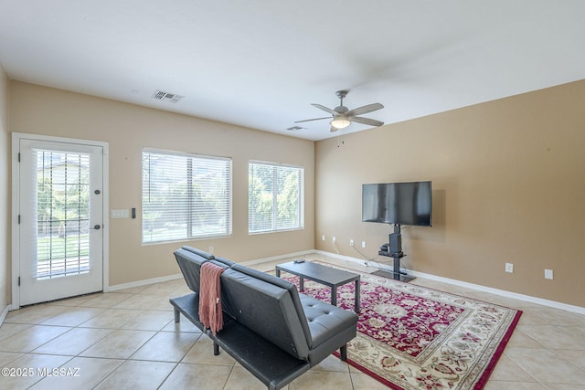 living room featuring light tile patterned floors, baseboards, a ceiling fan, and visible vents