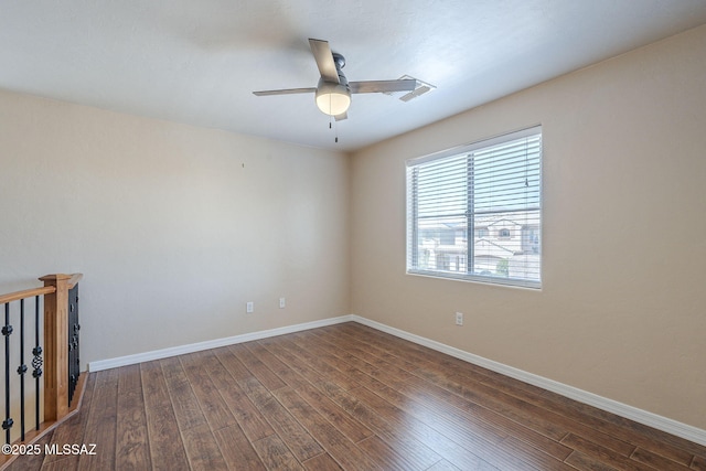 unfurnished room with ceiling fan, visible vents, dark wood-style floors, and baseboards