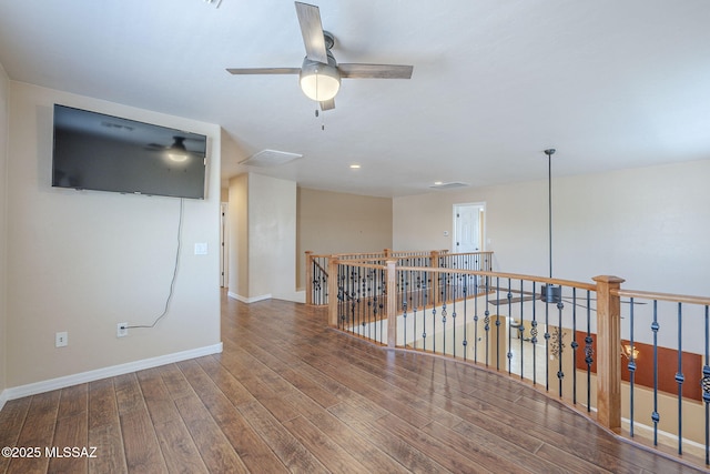 interior space with baseboards, a ceiling fan, and wood finished floors