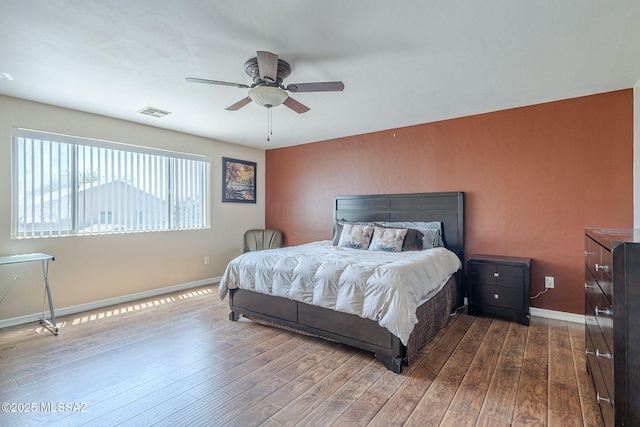 bedroom featuring dark wood-style flooring, baseboards, visible vents, and ceiling fan
