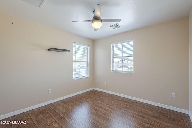spare room with baseboards, ceiling fan, wood finished floors, and visible vents