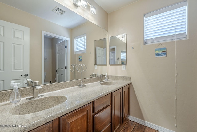 bathroom with visible vents, a sink, wood finished floors, and toilet
