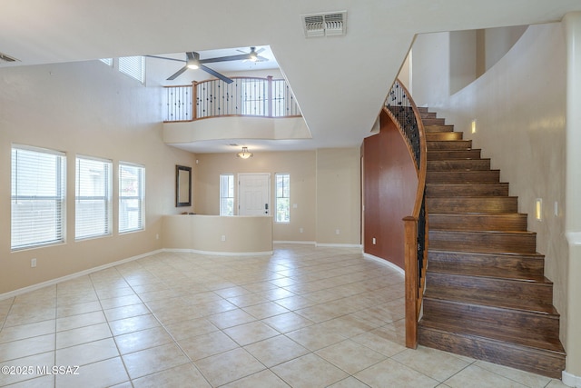 interior space with visible vents, ceiling fan, a high ceiling, and a healthy amount of sunlight
