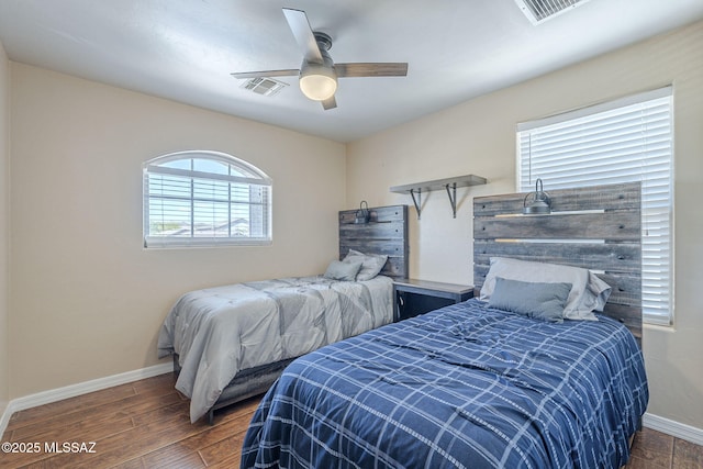 bedroom with a ceiling fan, baseboards, visible vents, and wood finished floors