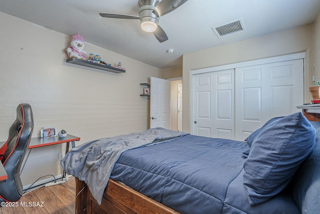 bedroom featuring visible vents, a ceiling fan, wood finished floors, and a closet