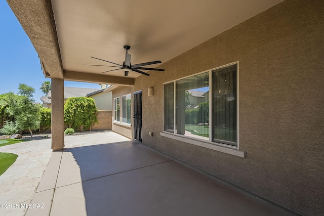 view of patio featuring ceiling fan and fence