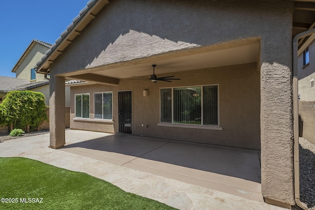back of house with a ceiling fan, a patio, and stucco siding