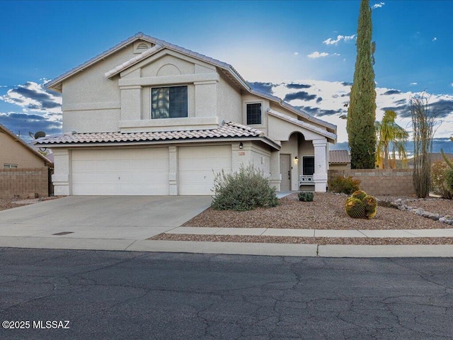 view of front facade featuring fence, an attached garage, stucco siding, concrete driveway, and a tiled roof