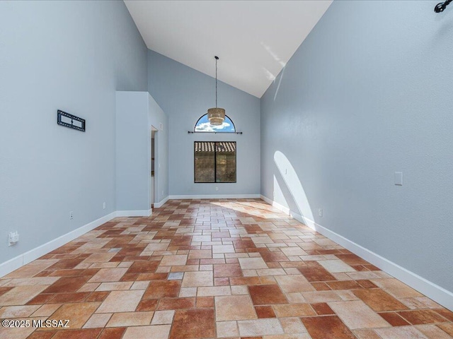 foyer featuring baseboards and a high ceiling