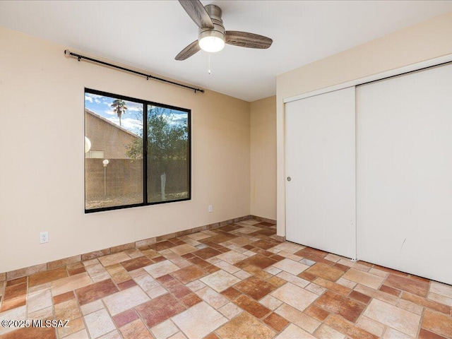 unfurnished bedroom with stone tile floors and a closet