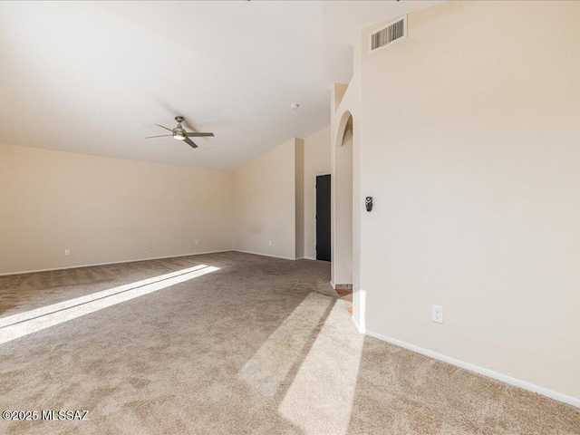 carpeted spare room featuring visible vents, lofted ceiling, baseboards, and ceiling fan