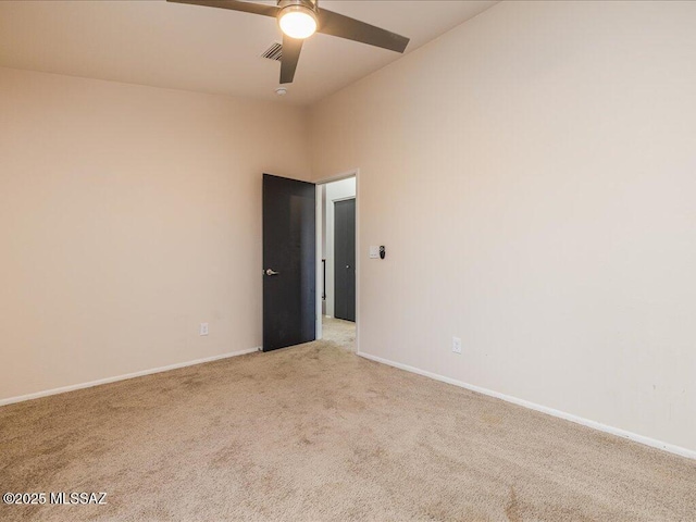 spare room with baseboards, light carpet, visible vents, and a ceiling fan