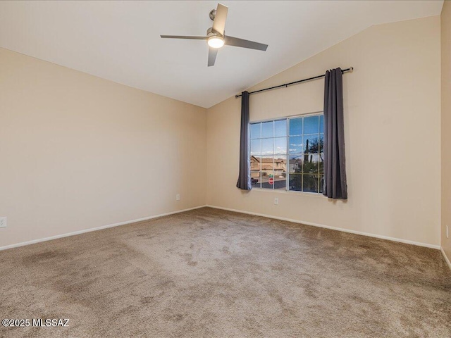 spare room with vaulted ceiling, carpet flooring, baseboards, and ceiling fan