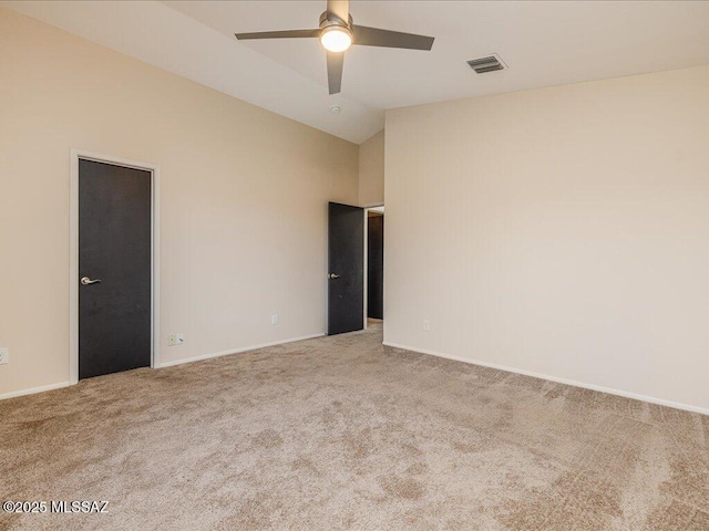 unfurnished room featuring visible vents, ceiling fan, lofted ceiling, and carpet