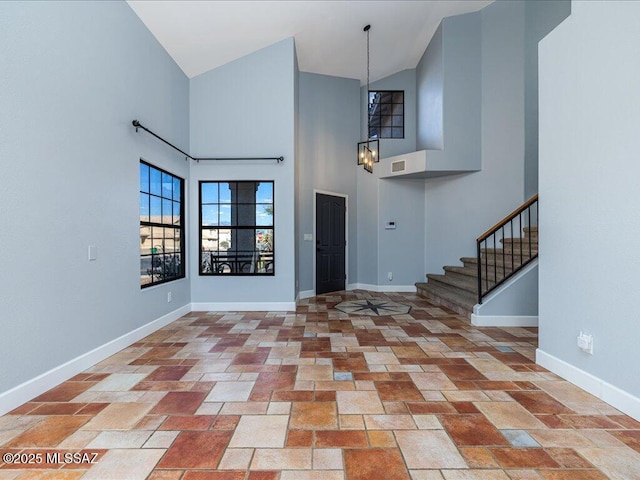 entrance foyer with visible vents, baseboards, high vaulted ceiling, an inviting chandelier, and stairs