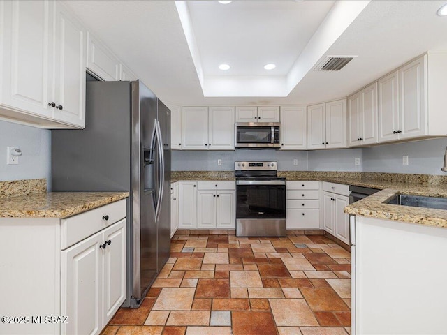 kitchen with visible vents, recessed lighting, appliances with stainless steel finishes, a raised ceiling, and a sink