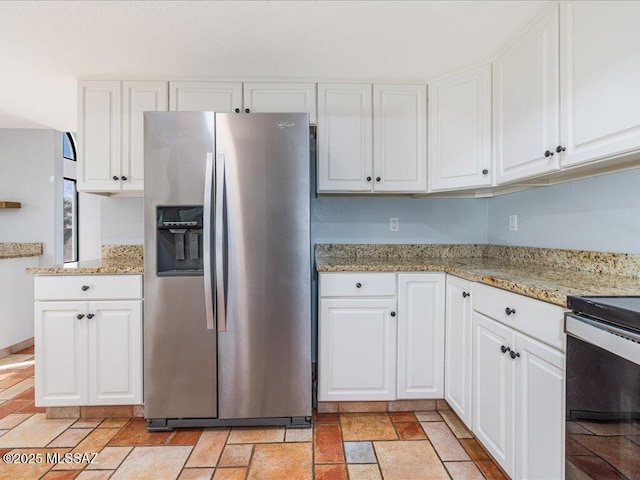 kitchen with white cabinetry, light stone countertops, stainless steel fridge, and electric range oven