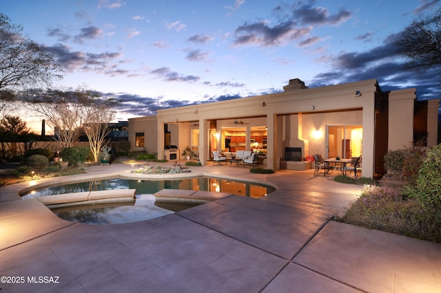 outdoor pool with outdoor dining space, an in ground hot tub, and a patio