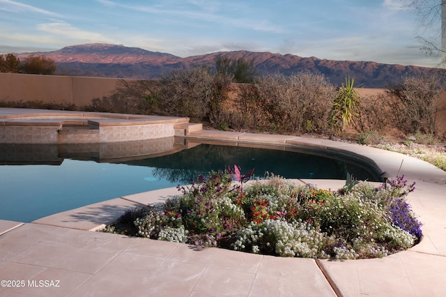 outdoor pool featuring a mountain view and an in ground hot tub