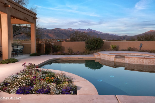 view of swimming pool with a patio, a fenced in pool, a fenced backyard, and a mountain view