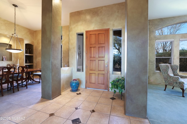 tiled foyer entrance featuring a towering ceiling