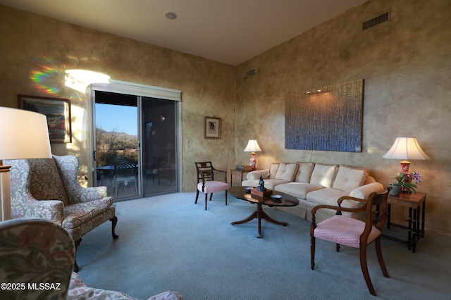 carpeted living room with visible vents and a high ceiling