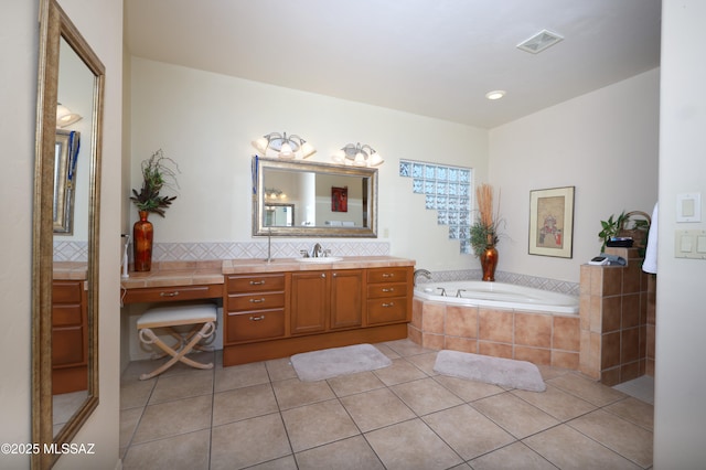 full bath with tile patterned flooring, vanity, backsplash, visible vents, and a garden tub