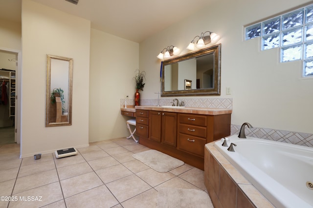 bathroom with a walk in closet, a bath, vanity, and tile patterned flooring