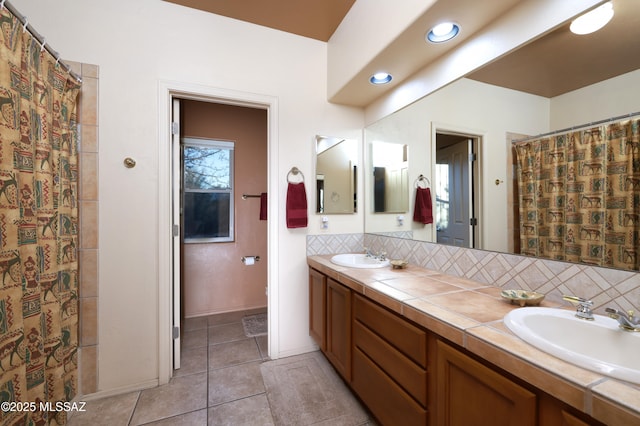 full bathroom with tile patterned flooring, backsplash, double vanity, and a sink