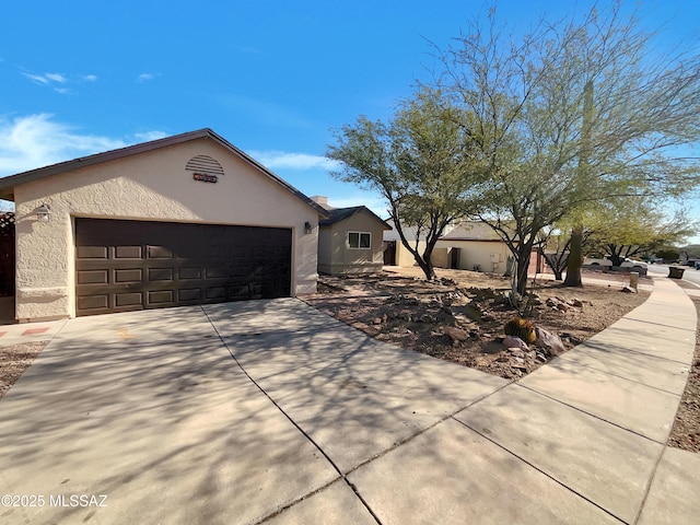 single story home with concrete driveway, a garage, and stucco siding