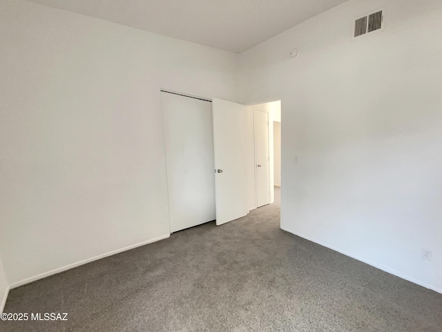 unfurnished room featuring visible vents, carpet floors, and baseboards