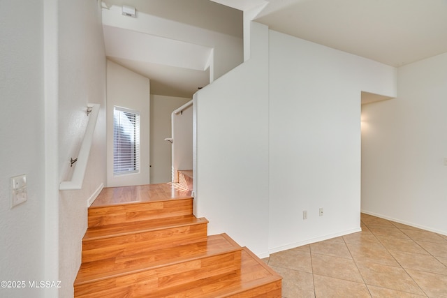 stairs featuring tile patterned floors and baseboards