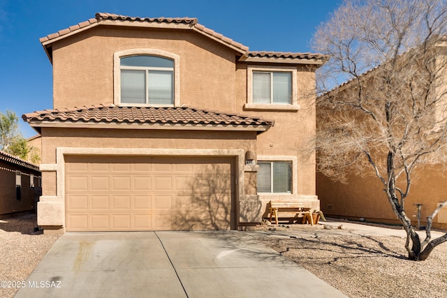 mediterranean / spanish house with a tile roof, stucco siding, an attached garage, and concrete driveway