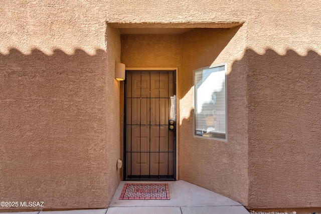 entrance to property with stucco siding