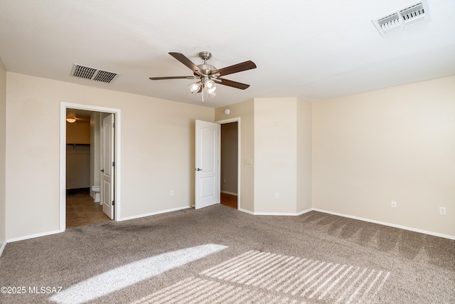 unfurnished bedroom featuring visible vents, carpet, and a walk in closet