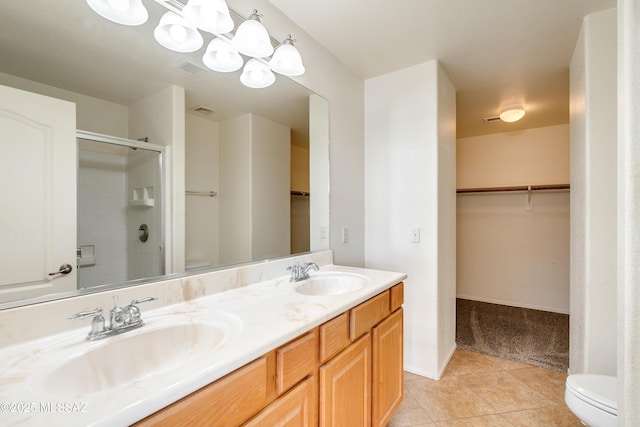 full bath featuring toilet, a shower with door, and a sink