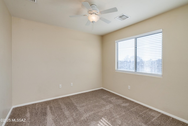 empty room with baseboards, carpet, visible vents, and ceiling fan