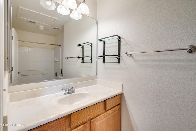 bathroom featuring visible vents, vanity, and a textured wall