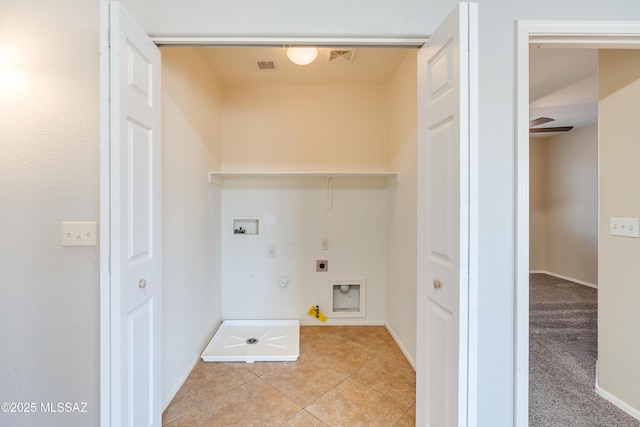 clothes washing area featuring gas dryer hookup, light tile patterned floors, laundry area, hookup for a washing machine, and electric dryer hookup