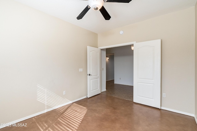 empty room featuring finished concrete floors, baseboards, and a ceiling fan