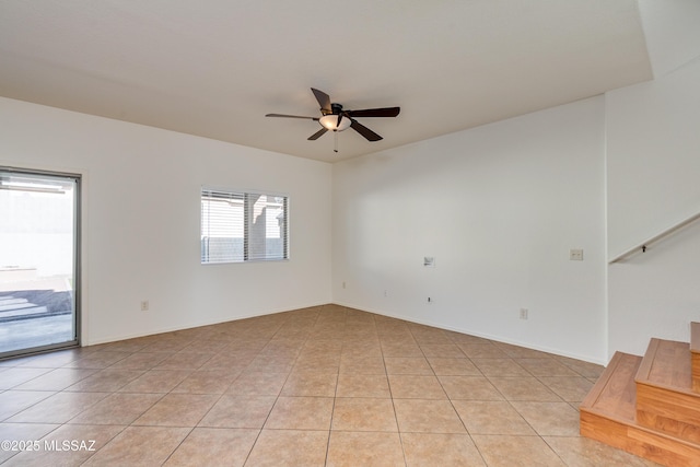 unfurnished room with light tile patterned floors, ceiling fan, and stairs