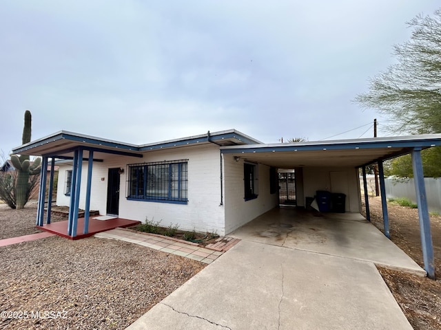 view of front of house with an attached carport, fence, and driveway