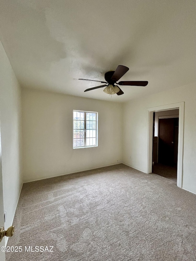 empty room with a ceiling fan and carpet