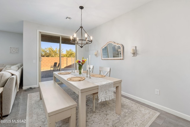 dining space featuring baseboards, visible vents, and a chandelier