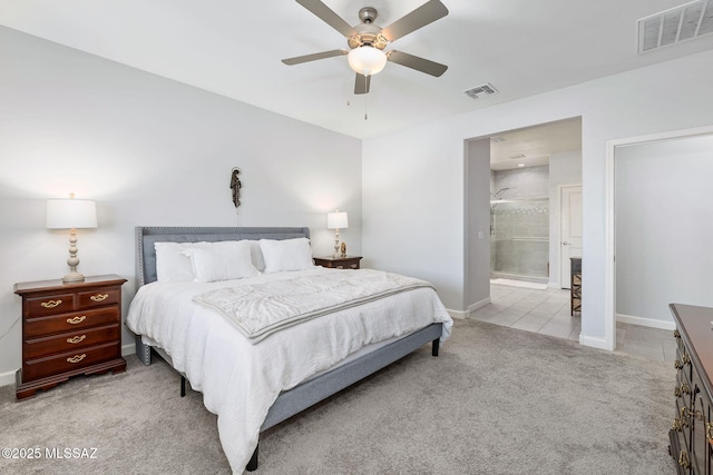 carpeted bedroom featuring ensuite bath, baseboards, and visible vents