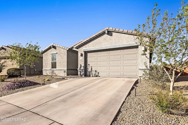 single story home with stucco siding, concrete driveway, an attached garage, and a tile roof