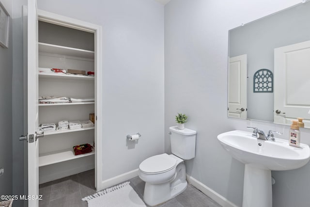 bathroom with tile patterned floors, toilet, and baseboards